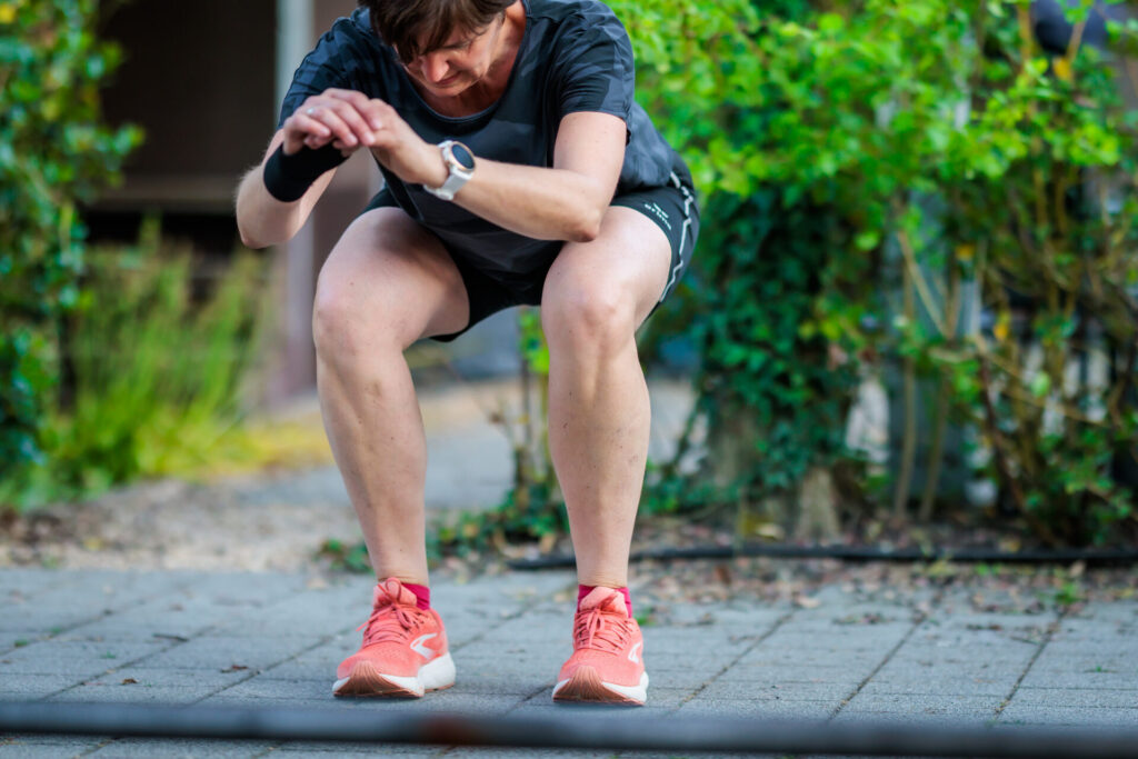 Klant in squatpositie tijdens de groepsles figuurtraining.